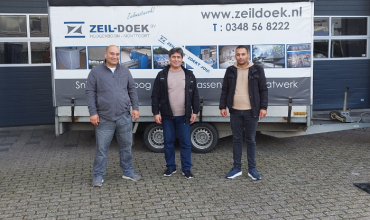 Drie deelnemers aan de Open Bedrijvendag in Montfoort staan voor een bord van Zeil-Doek B.V.