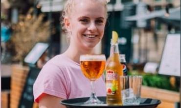 Serveerster met een dienblad met een paar drankjes erop