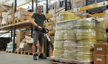 Een man houdt het handvat van een pompwagen vast.