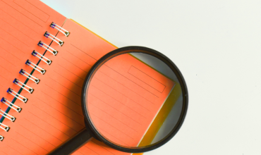 Oranje schrift met vergrootglas erop